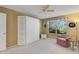 Bright bedroom features a built-in wardrobe with storage shelves and a cozy armchair at 720 Camino Del Rey Dr, The Villages, FL 32159