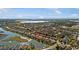 Panoramic aerial view of a residential community nestled along a picturesque lake under a sunny sky at 8780 Bridgeport Bay Cir, Mount Dora, FL 32757