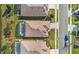 Backyard aerial view of property featuring a screened-in pool, complimented with lush landscaping, and neighboring houses at 8780 Bridgeport Bay Cir, Mount Dora, FL 32757