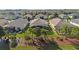 Aerial view of a backyard featuring screened lanai, lush landscaping, and mature trees at 8780 Bridgeport Bay Cir, Mount Dora, FL 32757