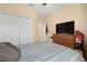 Bedroom featuring a plush bed, a closet, and an entertainment center with a TV, offering a relaxing space at 8780 Bridgeport Bay Cir, Mount Dora, FL 32757