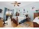 Sunlit bedroom with ceiling fan, outdoor access to patio, decorative stained-glass windows, and hardwood floors creating a cozy retreat at 8780 Bridgeport Bay Cir, Mount Dora, FL 32757