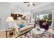 Open-concept living room with tile floors, stylish furnishings, and sliding doors to the patio at 8780 Bridgeport Bay Cir, Mount Dora, FL 32757