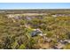 Expansive aerial view showcasing the property's sprawling lot, mature trees, and proximity to scenic ponds at 2600 Robie Ave, Mount Dora, FL 32757