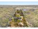 Aerial view of the property showcasing the house, landscaping, long driveway, and the surrounding green spaces at 2600 Robie Ave, Mount Dora, FL 32757
