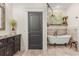 Elegant bathroom features a clawfoot tub, vanity with marble top, and stylish fixtures at 2600 Robie Ave, Mount Dora, FL 32757
