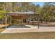 Rustic outdoor carport featuring wood beams and a concrete slab foundation surrounded by a grassy lawn at 2600 Robie Ave, Mount Dora, FL 32757