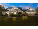 Stately home exterior at dusk with a manicured lawn, garden beds, and a three-car garage at 2600 Robie Ave, Mount Dora, FL 32757