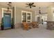 Inviting front porch featuring rocking chairs, stylish lighting, and a welcoming blue front door at 2600 Robie Ave, Mount Dora, FL 32757