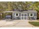 Gray shed with white trim, double doors, and flower boxes beside a gray water tank at 2600 Robie Ave, Mount Dora, FL 32757