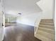 Bright living room featuring sleek dark floors, white walls, stairs, and a mirrored wall for added space at 1009 Royal Oak Blvd, Leesburg, FL 34748