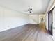 Bright living room with dark floors, white walls, stairs, and a sliding glass door to the patio at 1009 Royal Oak Blvd, Leesburg, FL 34748