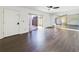 Inviting living room with dark floors, a sliding glass door to the patio, and a mirrored wall at 1009 Royal Oak Blvd, Leesburg, FL 34748