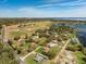 Aerial view showcasing the property, its well-maintained lawn, surrounding greenery, and proximity to a nearby lake at 10846 Point Nellie Dr, Clermont, FL 34711