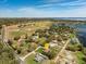 An aerial view of a home in a serene neighborhood, with a lake in the distance on a sunny day at 10846 Point Nellie Dr, Clermont, FL 34711