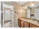 Bathroom featuring double sinks, wood cabinets, and a door leading to the outdoor area at 10846 Point Nellie Dr, Clermont, FL 34711