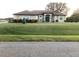 Charming single-story home featuring lush landscaping, a well-manicured lawn, and a welcoming green front door at 10846 Point Nellie Dr, Clermont, FL 34711