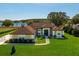 Beautiful single-story home featuring a well-maintained lawn and lake view with a brown roof at 10846 Point Nellie Dr, Clermont, FL 34711