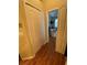 Hallway view leading to a bedroom, highlighting the wood flooring and closet space at 10846 Point Nellie Dr, Clermont, FL 34711