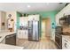 Well-lit kitchen with stainless steel refrigerator, white cabinets, quartz countertops, and decorative backsplash at 10846 Point Nellie Dr, Clermont, FL 34711