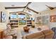 Cozy living room featuring exposed beams, large windows, and comfortable seating at 10846 Point Nellie Dr, Clermont, FL 34711