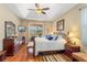 Inviting main bedroom features wood floors, a decorative ceiling, and a sliding door to the screened patio at 10846 Point Nellie Dr, Clermont, FL 34711