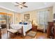 Inviting main bedroom with tray ceiling, en-suite, and a private balcony at 10846 Point Nellie Dr, Clermont, FL 34711