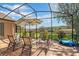 Screened in patio with comfortable seating and umbrella offers panoramic views of the beautiful backyard at 10846 Point Nellie Dr, Clermont, FL 34711