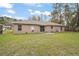 Large backyard features a sliding glass door, a well-maintained lawn and mature trees at 109 Pecan Pass, Ocala, FL 34472