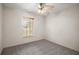 Minimalist bedroom featuring a ceiling fan, a window, and neutral carpet flooring at 109 Pecan Pass, Ocala, FL 34472