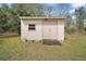 Small storage shed with double doors and a single window on a grassy lot at 109 Pecan Pass, Ocala, FL 34472