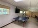 Large game room with ping pong table, TV, and storage cabinet at 1127 Belmont Cir, Tavares, FL 32778