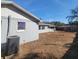 View of the backyard of the home showing the grass with visible dirt patches throughout at 115 N Galena Ave, Minneola, FL 34715