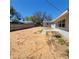 Expansive, sandy backyard with a concrete patio area extending from the rear of the house and a wooden fence at 115 N Galena Ave, Minneola, FL 34715