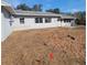 Wide shot of the backyard of the home showing dirt patches and some grass areas at 115 N Galena Ave, Minneola, FL 34715