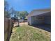 View of the backyard featuring a wooden fence, storage shed, and a partially covered patio area at 115 N Galena Ave, Minneola, FL 34715