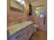 Vintage pink tile bathroom with sink, vanity, toilet, and mirrored medicine cabinet at 115 N Galena Ave, Minneola, FL 34715