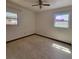 Standard bedroom featuring natural light from two windows and a ceiling fan at 115 N Galena Ave, Minneola, FL 34715