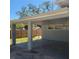 Exterior view of a covered carport with painted cement block walls and partial grass area at 115 N Galena Ave, Minneola, FL 34715