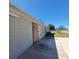 Exterior side of the home with gray painted brick and visible boarded door at 115 N Galena Ave, Minneola, FL 34715