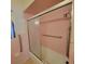 Vintage-style bathroom featuring a shower with glass door and pink ceramic tile at 115 N Galena Ave, Minneola, FL 34715