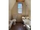 Attic Bathroom with a toilet, bathtub, and window at 1326 East Ave, Clermont, FL 34711