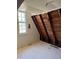 Attic Bedroom with exposed beams, a window, and white painted floors at 1326 East Ave, Clermont, FL 34711