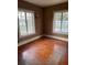 Bedroom features hardwood floors and natural light from dual windows with backyard views at 1326 East Ave, Clermont, FL 34711