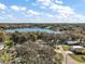 An aerial view showcases a neighborhood near a tranquil lake, surrounded by lush trees and greenery at 1391 E Crooked Lake Dr, Eustis, FL 32726