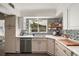 Well-lit kitchen featuring custom backsplash, plentiful counter space, and stainless steel dishwasher at 1391 E Crooked Lake Dr, Eustis, FL 32726