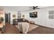 A comfortable living room featuring wood floors, a brown leather couch, and a large television at 1391 E Crooked Lake Dr, Eustis, FL 32726