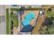 Aerial view of a community pool with lounge chairs, landscaping, and nearby building at 16707 Broadford Ln, Clermont, FL 34714