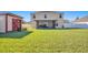 Spacious backyard with lush lawn, shed, and covered patio, perfect for entertaining at 16707 Broadford Ln, Clermont, FL 34714