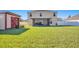 Large backyard showcasing a storage shed, a screened-in porch, and a well-maintained lawn at 16707 Broadford Ln, Clermont, FL 34714